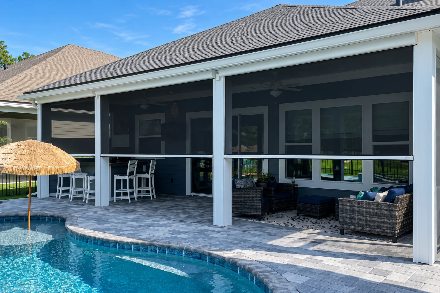 Screened patio beside a swimming pool, with white framing, dark mesh panels, and outdoor seating.